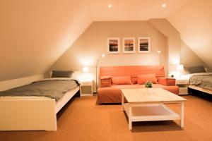 a attic bedroom with a bed and a couch at fewo1846 - Baltic Lodge - komfortable Maisonettewohnung mit 3 Schlafzimmern, Balkon und Blick auf die Marina Sonwik in Flensburg
