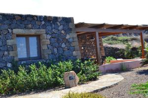 - un bâtiment en pierre avec une fenêtre sur le côté dans l'établissement Dammusi Sotto le Stelle, à Pantelleria