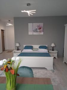 a bedroom with a large white bed and two chairs at Studio Timeea Mamaia-Nord in Năvodari