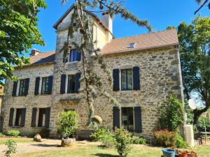 Sainte-Croix的住宿－Chambres et table d'hôtes Le cèdre Aveyron，一座带黑色百叶窗的古老石屋