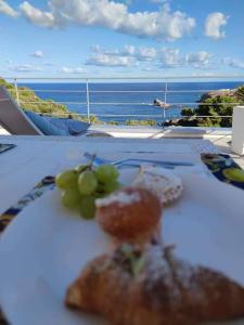 a plate of food on a table with a view of the ocean at Zabbàra B&B in Terrasini