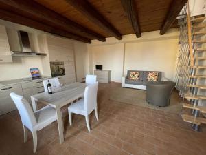 eine Küche und ein Esszimmer mit Tisch und Stühlen in der Unterkunft conGusto Apartments in Cherasco