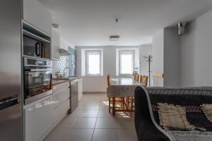 uma cozinha com uma mesa e uma bancada em Le bélier 2nd étage avec balcon au centre ville d'Embrun em Embrun