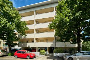 a red car parked in front of a building at Residence Columbia in Bibione