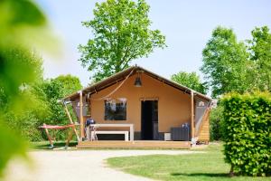 a small house with a porch and a swing at Glamping Limburg in Oostrum