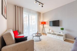 a living room with a couch and a tv at Grobla by Loft Apartments in Gdańsk