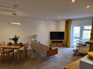 a living room with a table and a television at No 3 king street apartment and snug in Seahouses