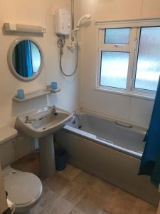 a bathroom with a tub and a sink and a toilet at Stonygarth Cabin in Crosby Garrett