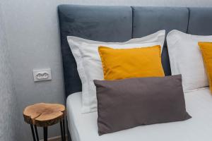 a bed with white pillows and yellow pillows at Apartment in the Center Gray Garden in Kaliningrad