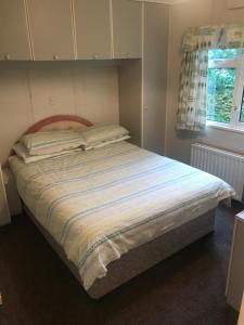 a large bed in a bedroom with a window at Stonygarth Cabin in Crosby Garrett