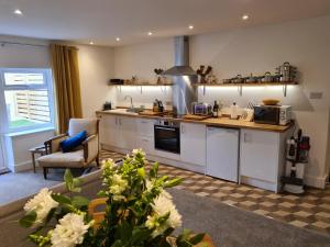 a kitchen with white cabinets and a counter top at No 3 king street apartment and snug in Seahouses