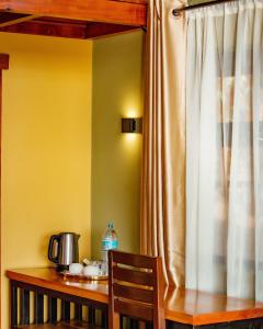 a wooden table with a wooden chair and a curtain at Shamba lodge arusha in Olmotoni