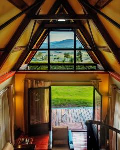 an attic room with a large window in a house at Shamba lodge arusha in Olmotoni