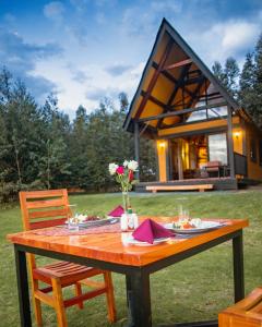 a wooden table in front of a small house at Shamba lodge arusha in Olmotoni