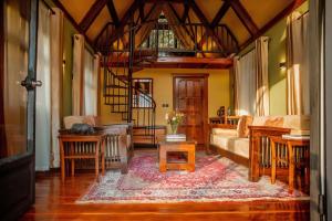 a living room with a couch and a spiral staircase at Shamba Lodge Cabin C in Olmotoni