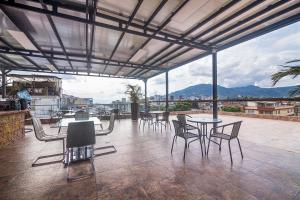 un patio con mesas y sillas en la parte superior de un edificio en Bayit Tov Circunvalar Hotel en Pereira