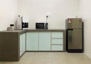 a kitchen with a microwave and a refrigerator at Amadel Residence 爱媄德民宿 16 in Melaka