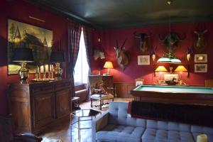 a living room with a couch and a pool table at Chateau de Vaux in Yvré-lʼÉvêque