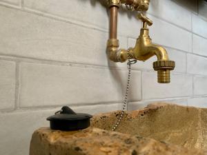 a gold water faucet with a black hat on a rock at Workation - La Casita de Elsi y Fran in Costa Calma