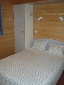 a bedroom with a white bed with a wooden headboard at Le Mazet des Cigales in Vers Pont du Gard
