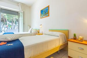 1 Schlafzimmer mit 2 Betten und einem Fenster in der Unterkunft Appartamento Il Timone 1 Piano - MyHo Casa in Alba Adriatica