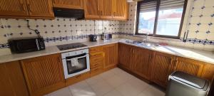 cocina con armarios de madera, fregadero y microondas en 402 - Oura - 2 Bedroomed Apartment - Sea View, en Albufeira