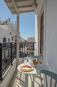a table with a plate of food on a balcony at Beach Connection Naxos town in Naxos Chora