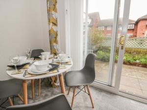 a dining room with a table and chairs and a window at 40 Lloyd Street West in Llandudno