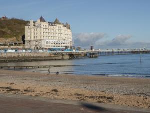 a large building on the beach next to the ocean at 40 Lloyd Street West in Llandudno