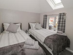 two beds sitting next to each other in a bedroom at 31 Lloyd Street West in Llandudno