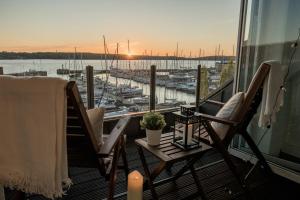 a balcony with two chairs and a table with a view of a harbor at fewo1846 - Baltic Lodge - komfortable Maisonettewohnung mit 3 Schlafzimmern, Balkon und Blick auf die Marina Sonwik in Flensburg