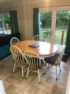 a wooden table and chairs in a room at Stonygarth Cabin in Crosby Garrett