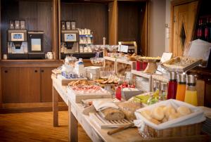 a buffet with bread and other food on a table at Hotel Funivia in Bormio