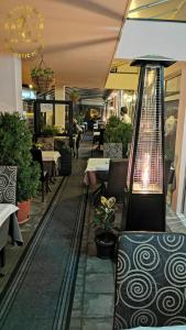 un ristorante con tavoli, sedie e lampadario a braccio di Zlatna Ribica a Golubac