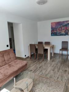 ein Wohnzimmer mit einem Sofa, einem Tisch und Stühlen in der Unterkunft Apartment Tony in Interlaken