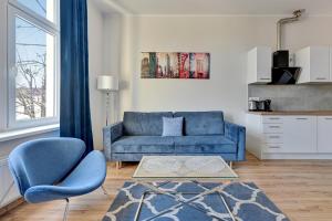 salon z niebieską kanapą i stołem w obiekcie Blue Mandarin Apartments III Haffnera w mieście Sopot