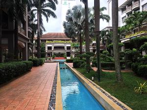 a pool in the middle of a building with palm trees at Amadel Residence 爱媄德民宿 16 in Malacca
