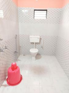 a pink bathroom with a toilet and a sink at Udita (উদিতা) Eco Homestay Santiniketan in Shānti Niketan +39 photos