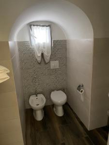 a bathroom with a toilet and a sink and a window at Exclusive Rooms in Trinitapoli +10 photos