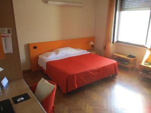 Habitación de hotel con cama con manta roja en Affittacamere ACCASA, en Prato