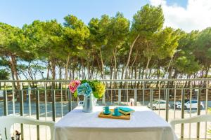 einen Tisch mit einer Vase aus Blumen und Büchern in der Unterkunft Appartamento Il Timone 1 Piano - MyHo Casa in Alba Adriatica
