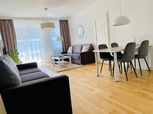 a living room with a table and chairs and a couch at Apartamenty Maritimo in Kołobrzeg