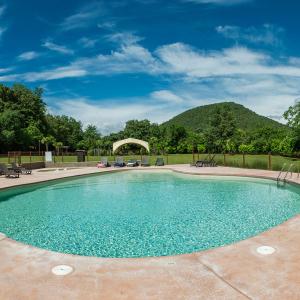 una piscina in un cortile con montagne sullo sfondo di ACAMPALE - Glamping La Garrotxa - Santa Pau a Santa Pau