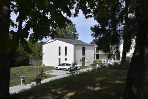 una casa blanca con un coche aparcado en la entrada en Sonnenscheinhaus Wohnung 2, en Erlenbach