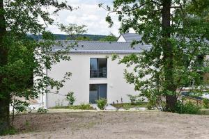 una casa blanca con árboles delante de ella en Sonnenscheinhaus Wohnung 2, en Erlenbach
