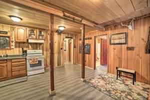 a kitchen with wooden walls and wooden floors and a stove at Remote Kentucky Cabin with Fire Pit and 2 Ponds in New Concord