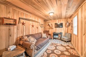 a living room with a couch in a room with wooden walls at Remote Kentucky Cabin with Fire Pit and 2 Ponds in New Concord
