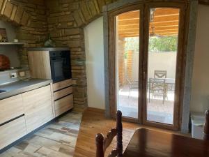 a kitchen with a table and a kitchen with a sliding glass door at VILLA NAZZA in Anguillara Sabazia