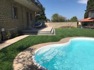 a swimming pool in the yard of a house at VILLA NAZZA in Anguillara Sabazia