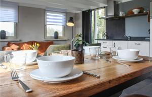 einem Holztisch mit weißen Tassen und Tellern darauf in der Unterkunft Beautiful Home In Bornerbroek With House A Panoramic View in Weleveld